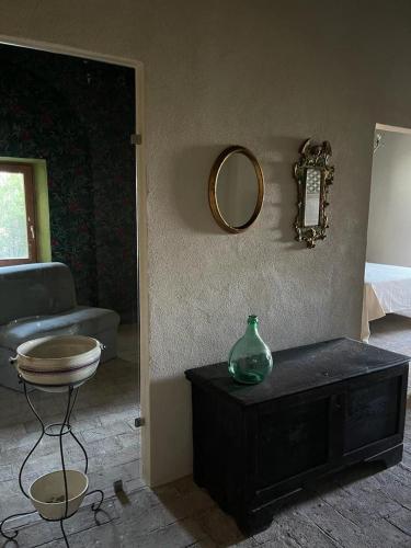 a room with a vase on a table and a mirror at L'Incanto di Civita in Bagnoregio
