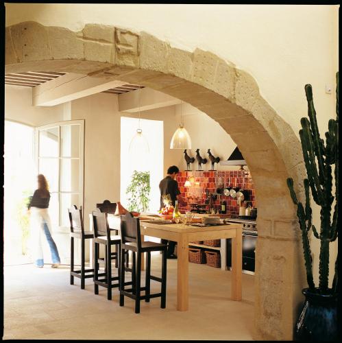 a kitchen and dining room with a table and chairs at La Maison Sur La Sorgue - Esprit de France in LʼIsle-sur-la-Sorgue