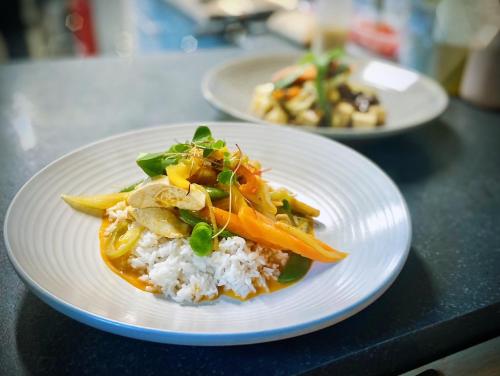 un plato blanco con arroz y verduras en una mesa en Inversnaid Bunkhouse en Inversnaid
