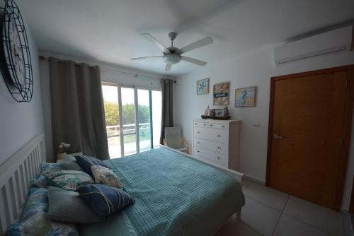 a bedroom with a bed and a ceiling fan at Atmospheric apartment with a beautiful view of the swimming pool in Bayahibe