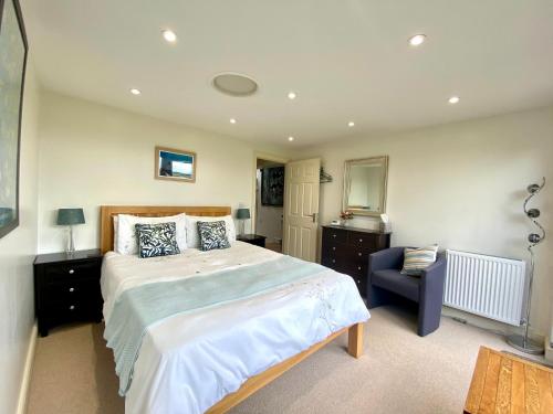 a bedroom with a large bed and a chair at A secluded self contained Country Suite with a view - parking, easy access to Bath in Corsham
