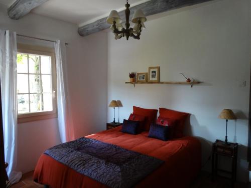 - une chambre avec un lit doté de draps rouges et d'oreillers bleus dans l'établissement Le Clos du Tilleul, à Saint-Michel-lʼObservatoire