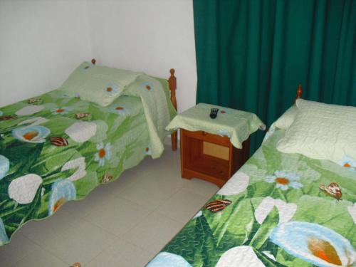 a bed room with two beds and a desk at Pension El Guanche in Frontera