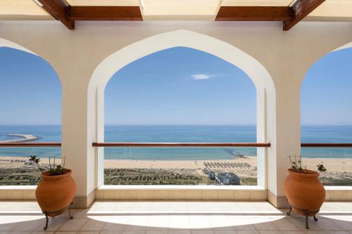an arched window in a building with a view of the ocean at Crowne Plaza Vilamoura - Algarve by IHG in Vilamoura