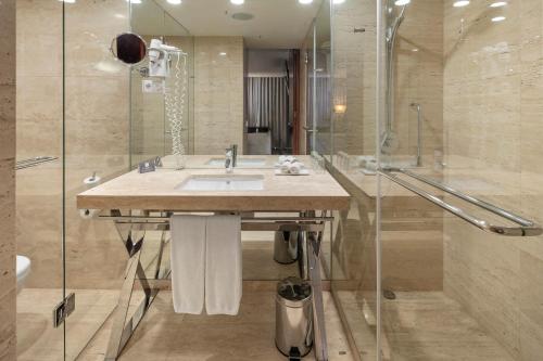 a bathroom with a sink and a shower at Crowne Plaza Vilamoura - Algarve by IHG in Vilamoura