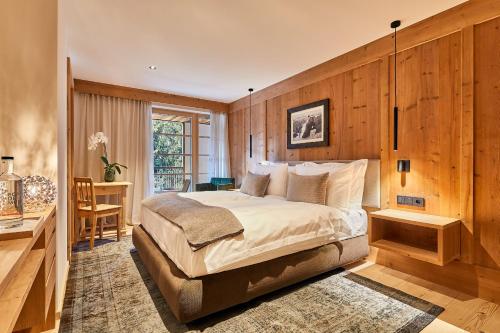 um quarto com uma cama, uma secretária e uma janela em Residence Villa Al Sole em Corvara in Badia