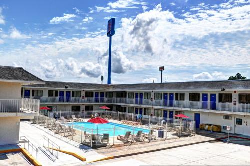 a large building with a swimming pool and chairs at Motel 6-Slidell, LA - New Orleans in Slidell