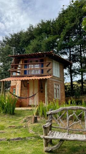 a wooden house with a bench in front of it at Pousada Alquimia in Aiuruoca