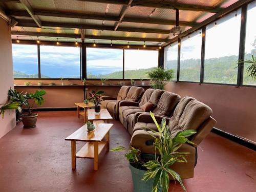 um quarto amplo com sofás, mesas e janelas em Buena Vista Boquete em Boquete
