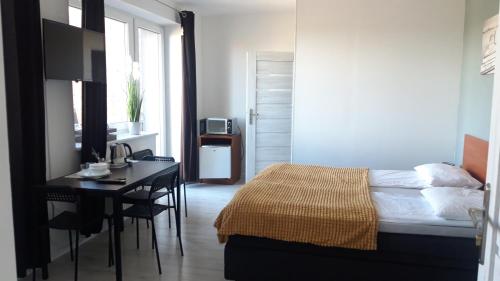 1 dormitorio con escritorio, 1 cama, mesa y sofá cama en Azalia 32 Mielno l, en Mielno