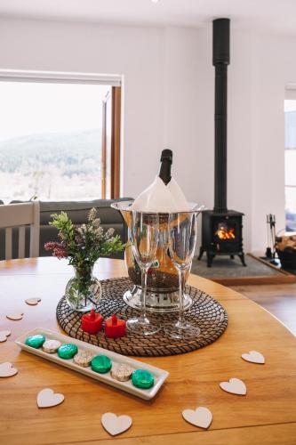 a table with a wine glass and cookies on it at Frances' Sketch Pad with Hot Tub in Fort William