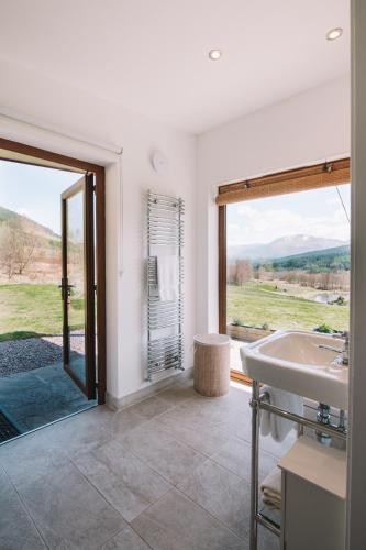 a bathroom with a tub and a sink and a window at Frances' Sketch Pad with Hot Tub in Fort William