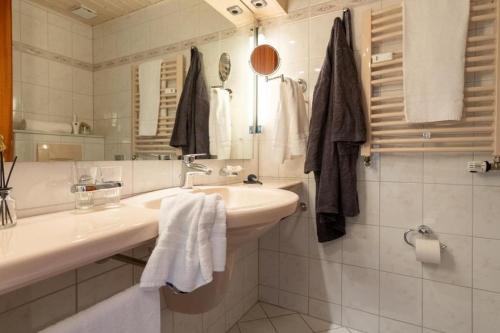 a white bathroom with a sink and a mirror at Haus-Schwanensee-Wohnung-27-Kajaknutzung-inklusive in Bosau