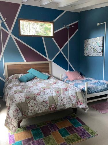 a bedroom with a bed and a geometric wall at AUSVIA cabañas tinajas y spa in Hornopiren