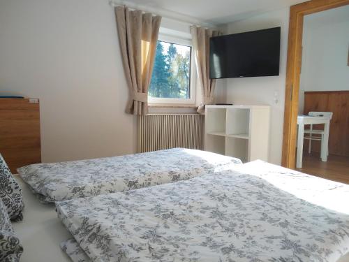 a bedroom with two beds and a flat screen tv at Sauschneidhof - Radstadt in Radstadt