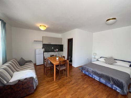ein Schlafzimmer mit einem Bett, einem Tisch und einem Sofa in der Unterkunft Apartments Antolkovic in Ugljan