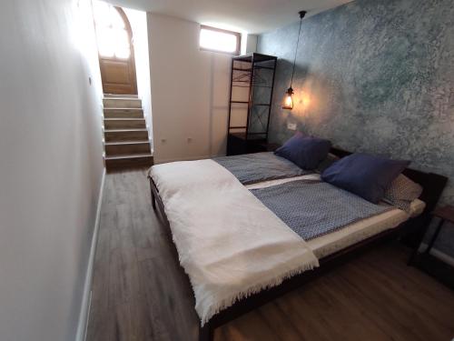 a bedroom with a large bed with blue pillows at Napraszállás Vendégház in Balatonakali