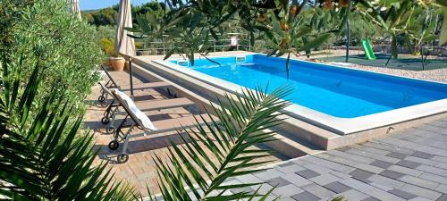 a swimming pool in a yard with a palm tree at Apartments AS in Jezera