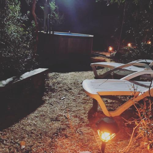 a couple of benches in a yard at night at AUSVIA cabañas tinajas y spa in Hornopiren