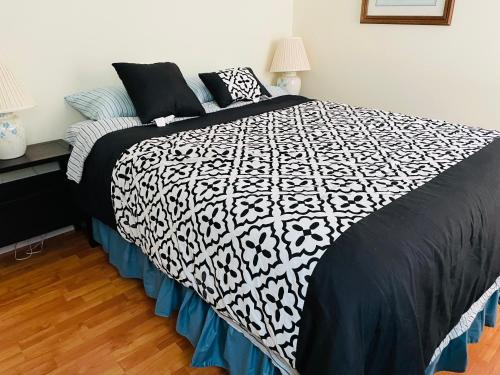 a bed with a black and white comforter in a bedroom at Beach Boutique Apartment in Old Orchard Beach