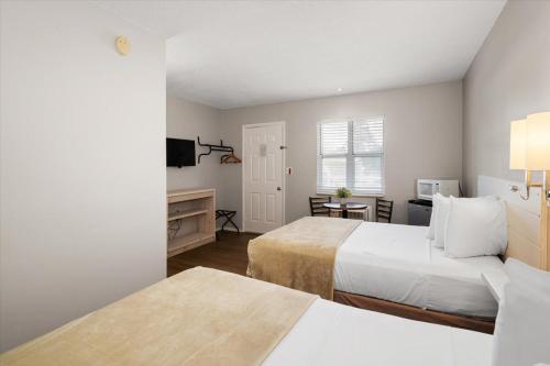 a hotel room with two beds and a desk at Beach Bum West-O Motel in Ocean City