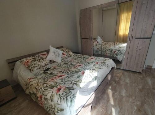 1 dormitorio con 1 cama con colcha de flores en Big Seafront Apartment in Saida Lebanon en Saïda