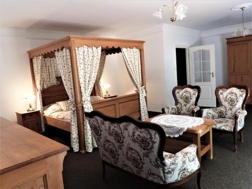 OsiekiにあるDworek Osieckiのベッドルーム1室(ベッド1台、テーブル、椅子付)