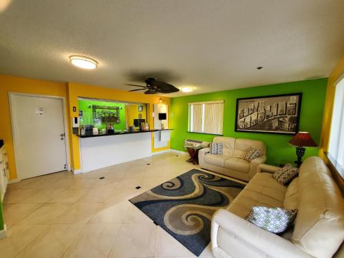 sala de estar con paredes verdes y sofá en Coastal Inn & Suites, en Wilmington
