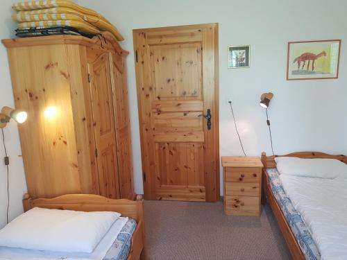 1 dormitorio con 2 camas y puerta de madera en Bot Sundroina (329 Pe) Whg. 2.3, en Lenzerheide