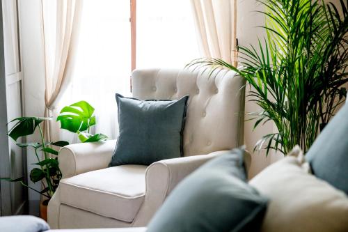 a living room with a white chair and plants at Antichi Casali di Charme in Orvieto