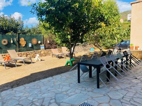 a picnic table and chairs next to a tree at Casa Nova Maison d'hôtes in Sagone