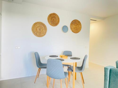 Un comedor con una mesa blanca y sillas azules en Ground flor apartament in Turquesa del Mar, Playa Flamenca, en Orihuela
