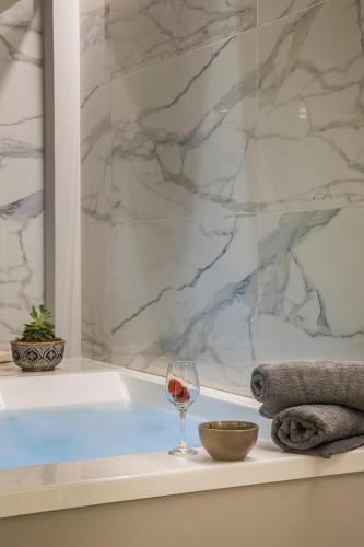 a glass of wine sitting on a bath tub with a glass of wine at Anthélia villa in Kefallonia