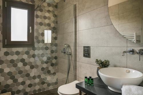 a bathroom with a sink and a shower and a toilet at Anthélia villa in Kefallonia