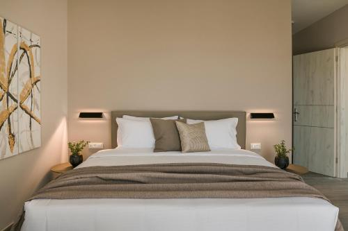 a bedroom with a large white bed with pillows at Anthélia villa in Kefallonia
