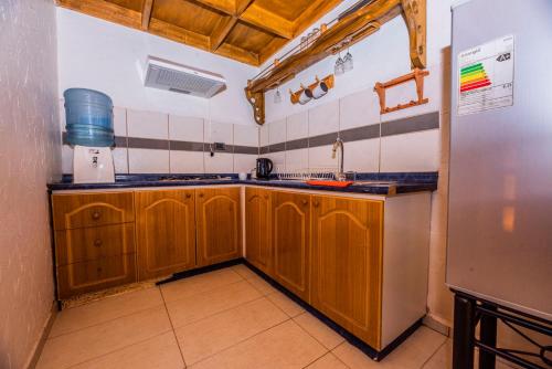 a kitchen with wooden cabinets and a refrigerator at Hotel Parina Atacama in San Pedro de Atacama