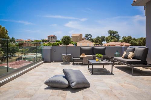 a patio with chairs and a table on a balcony at Anthélia villa in Kefallonia