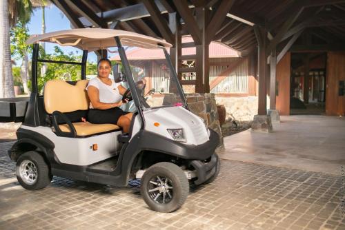 a man is sitting in a golf cart at Les Villas du Lagon in Le François