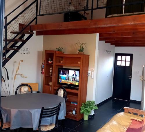 ein Wohnzimmer mit einem Tisch und einem TV in der Unterkunft Amancay in Villa Elisa