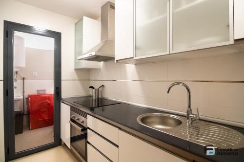 a kitchen with white cabinets and a sink at Apartamento Residencial Mirador Playa Serena in Roquetas de Mar