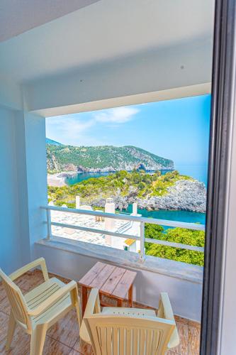 a balcony with a table and chairs and a view of the ocean at The Life Suites in Limniónas