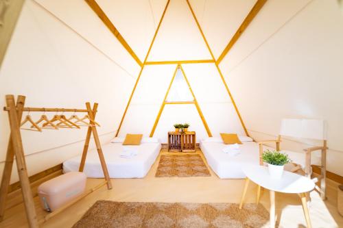 a room with white furniture in a tent at Kampaoh Somo Parque Playa in Somo