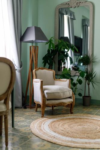 a living room with a chair and a mirror at Antichi Casali di Charme in Orvieto