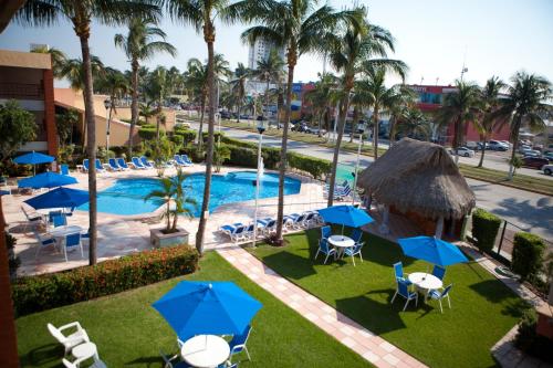 een luchtzicht op een zwembad van het resort met stoelen en parasols bij Hotel Jaragua in Veracruz