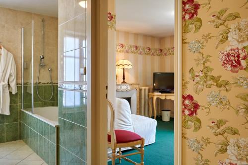 a bathroom with a tub and a bedroom at Le Clos De Bourgogne in Moulins