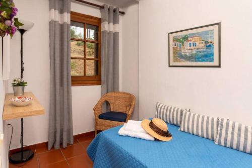 a bedroom with a bed and a chair and a window at Seaside House with view over Pagasitikos in Afissos