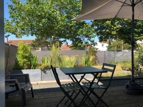 a table and chairs and an umbrella on a deck at Le defi in Fouras