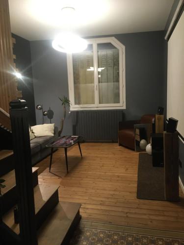 un salon avec un canapé et une fenêtre dans l'établissement Maison cosy à 2km du circuit bugatti des 24h, au Mans