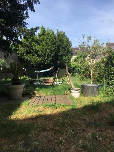 une cour avec un hamac, des arbres et de l'herbe dans l'établissement Maison cosy à 2km du circuit bugatti des 24h, au Mans