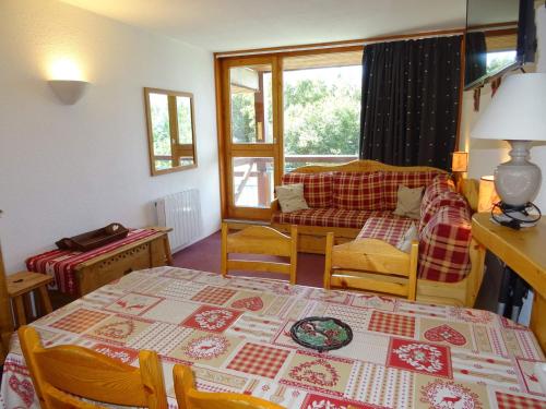 un salon avec une table et un canapé dans l'établissement Studio cosy pour 5 pers, proche pistes et commerces, WiFi, lave-vaisselle - FR-1-411-53, à Arc 1800